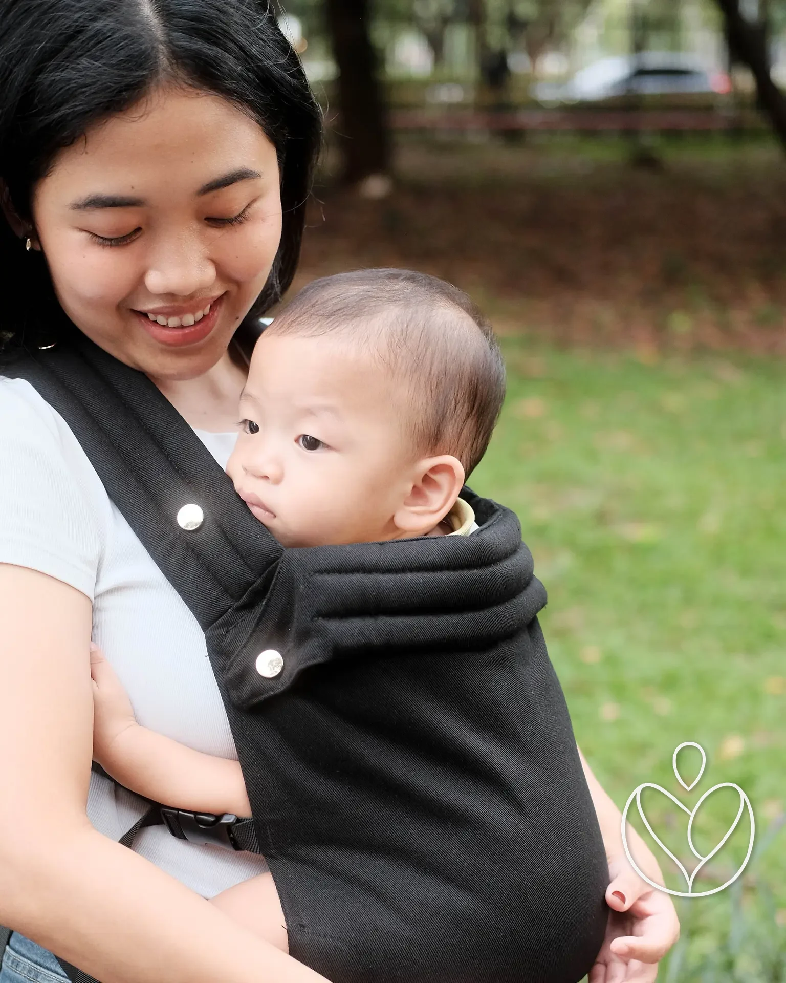 Orang tua dan bayi memakai gendongan Keenaa